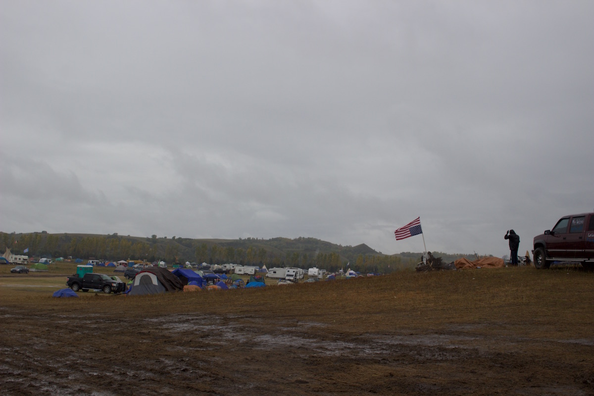 Upside-down flag flies over Oceti Sakowin (Photo: Nadya Tannous)